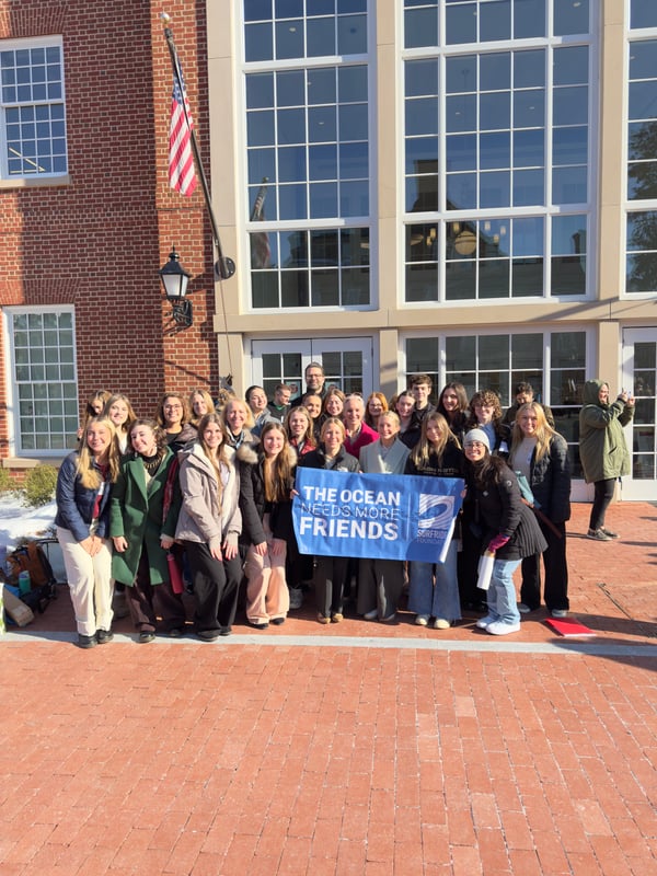 A group of volunteers posing with a sign that says 
