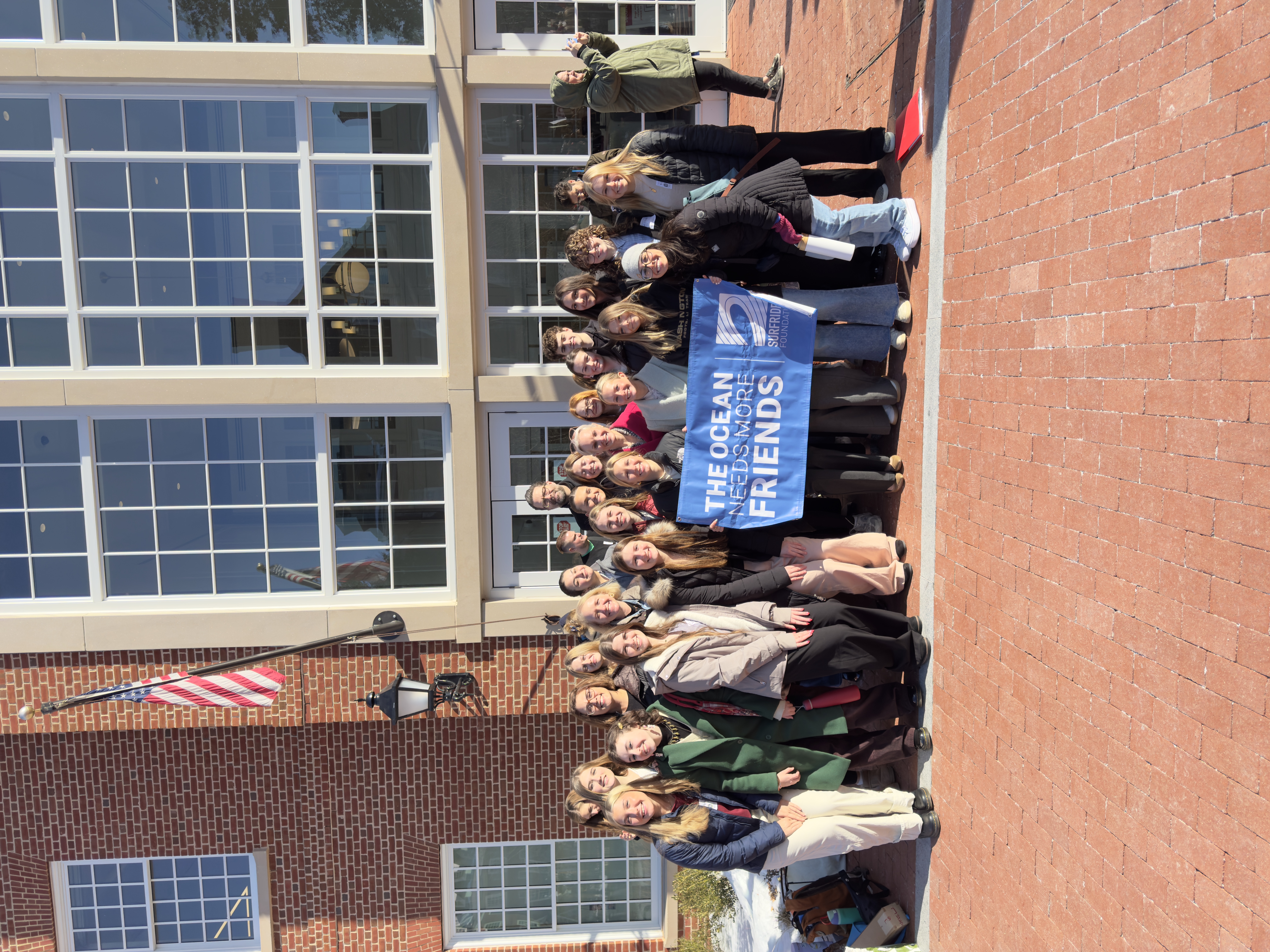 A group of volunteers posing with a sign that says 